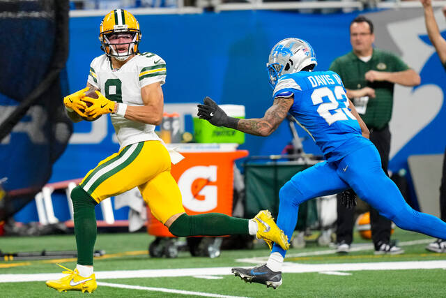 Green Bay Packers wide receiver Christian Watson makes a catch in front of Detroit Lions cornerback Carlton Davis III.
