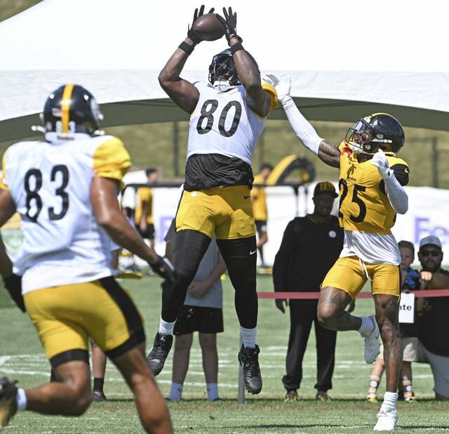 Pittsburgh Steelers tight end Darnell Washington pulls in a touchdown pass over safety DeShon Elliot (25) as tight end Connor Heyward (83) watches during a training-camp practice in August at Saint Vincent College.
