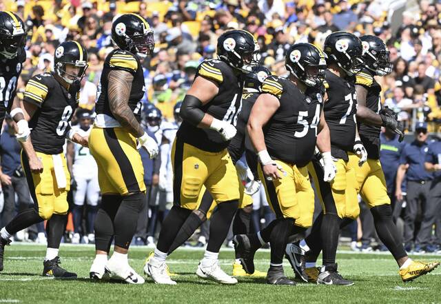 Members of the Pittsburgh Steelers offensive line break the huddle in front of quarterback Aaron Rodgers breaks the huddle with the during a game earlier this season at Acrisure Stadium. The Steelers’ offensive line has shown steady improvement as the season has progressed.