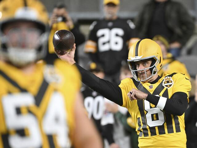 Pittsburgh Steelers center Zach Frazier (foreground) warns up while quarterback Aaron Rodgers throws before Sunday night’s game against the Green Bay Packers at Acrisure Stadium. Frazier played despite a calf injury that had him listed as questionable headed into the weekend.