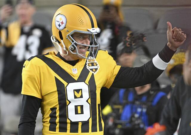 Wearing the Pittsburgh Steelers’ throwback jersey, quarterback Aaron Rodgers gives a thumbs-up during warm-ups before Sunday night’s game against the Green Packers at Acrisure Stadium.