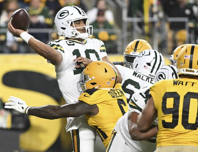 Packers quarterback Jordan Love throws as he is being hit by the Steelers’ Patrick Queen in the third quarter Sunday at Acrisure Stadium.
