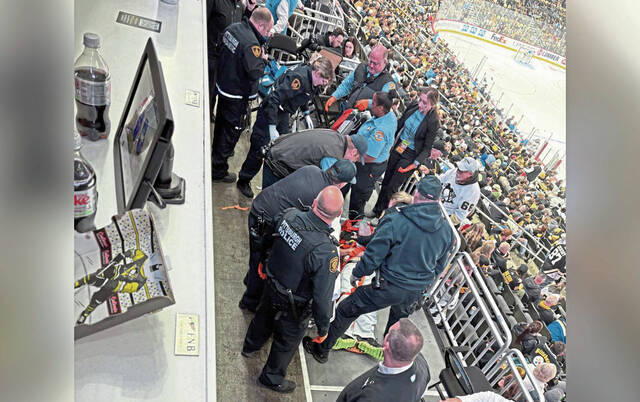First responders treat a fan who fell from the stands Monday night at PPG Paints Arena during a Pittsburgh Penguins game.