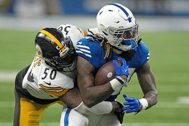 Colts running back Trey Sermon is tackled by Steelers linebacker Elandon Roberts in a Dec. 16, 2023, game in Indianapolis.