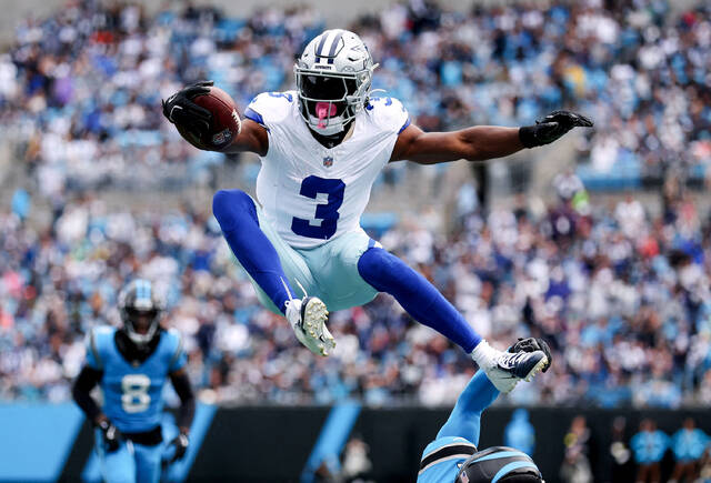 Cowboys wide receiver George Pickens jumps over Carolina Panthers safety Nick Scott in an Oct 12 game at Bank of America Stadium in North Carolina.