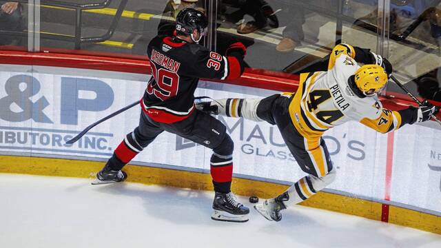 Utica Comets forward Mike Hardman hits Wilkes-Barre/Scranton Penguins defenseman Chase Pietila during a game at the Utica (N.Y.) Memorial Auditorium on Saturday. The Comets won, 3-1.