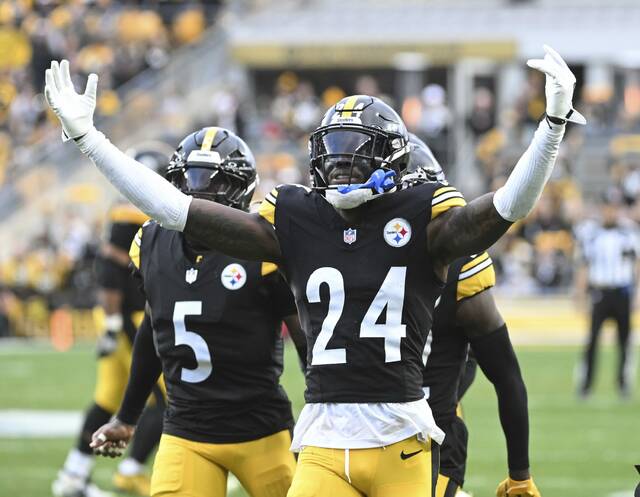 Pittsburgh Steelers cornerback Joey Porter Jr. (No. 24) celebrates making an interception late during Sunday’s win against the Indianapolis Colts at Acrisure Stadium. Defensive back Jalen Ramsey (No. 5) looks on.