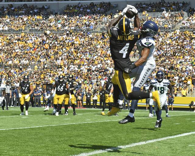 Pittsburgh Steelers wide receiver DK Metcalf pulls in a touchdown pass over Seattle Seahawks defensive back Coby Bryant during a game earlier this season at Acrisure Stadium.