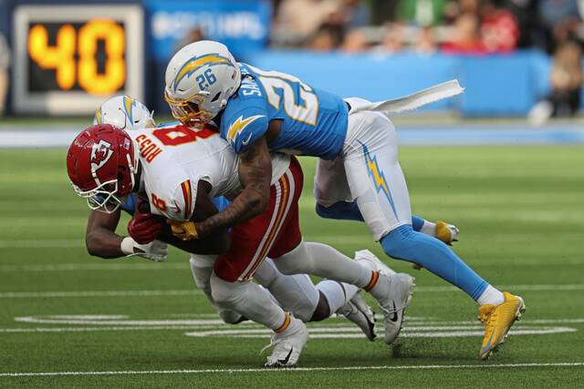 Los Angeles Chargers cornerback Asante Samuel Jr. tackles Kansas City Chiefs wide receiver Justyn Ross in a Jan 7, 2024, game at SoFi Stadium in Inglewood, Calif.