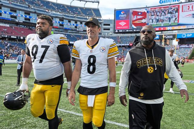 Pittsburgh Steelers defensive tackle Cameron Heyward (97) and quarterback Aaron Rodgers join coach Mike Tomlin in leaving the field together after a victory at the New England Patriots in September. Rodgers and Heyward are longtime NFL team captains who this season have formed a leadership bond with the Steelers.