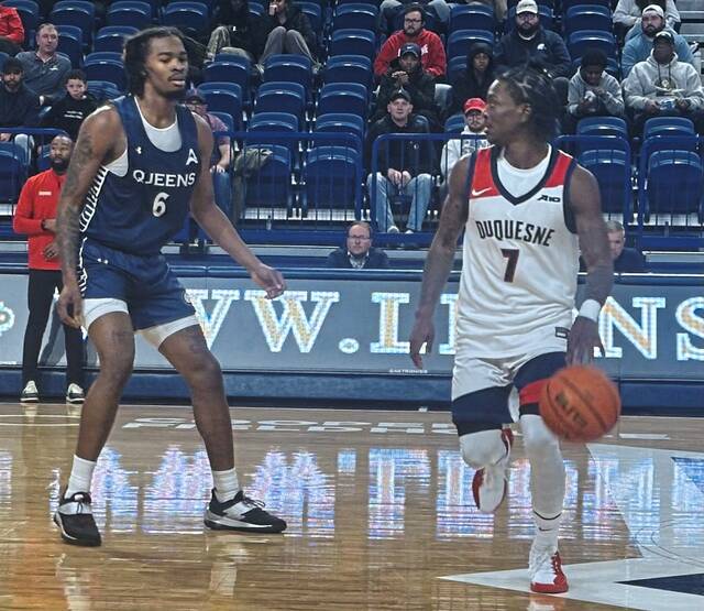 Duquesne's Dom Aekins looks to pass the ball in front of Queens' Avantae Parker on Tuesday, Nov. 11, 2025, at UPMC Cooper Fieldhouse.