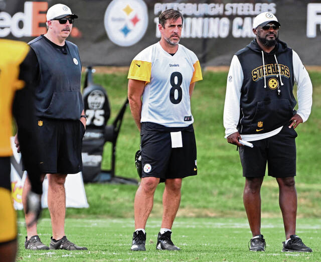 Shown during a photo from training camp while he stands between offensive coordinator Arthur Smith and head coach Mike Tomlin, Pittsburgh Steelers quarterback Aaron Rodgers carries an official designation of questionable to play in Sunday’s game at the Chicago Bears. Rodgers has a lift wrist fracture.
