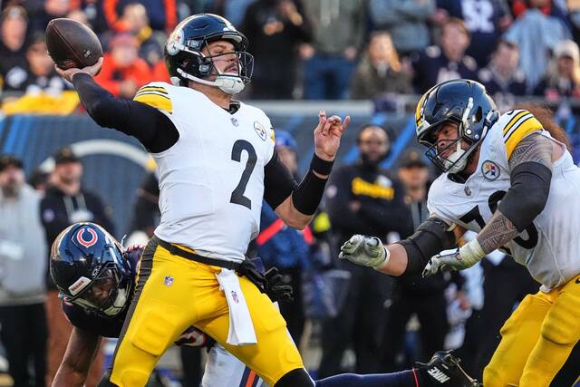 Pittsburgh Steelers quarterback Mason Rudolph looks to throw a pass while under pressure from Chicago Bears linebacker Amen Ogbongbemiga, left, with Steelers’ Isaac Seumalo, right, defending during the second half of an NFL football game Sunday, Nov. 23, 2025, in Chicago.