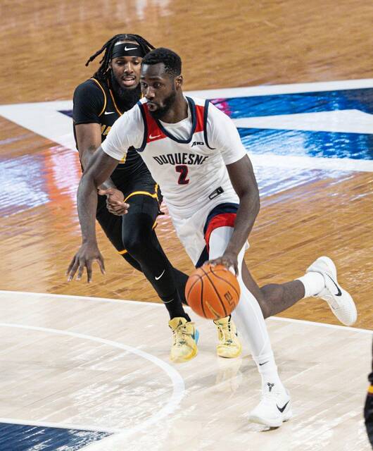 Duquesne’s David Dixon dribbles past Central State’s Emanuel Henriques on Wednesday at UPMC Cooper Fieldhouse.