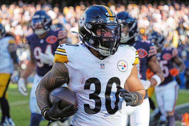Pittsburgh Steelers running back Jaylen Warren (30) carries the ball into the end zone for a touchdown during the first half of an NFL football game against the Chicago Bears, Sunday, Nov. 23, 2025, in Chicago.