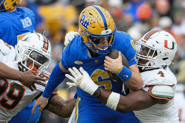 Pitt quarterback Mason Heintschel (6) is sacked by Miami's Rueben Bain Jr. (4) and Ahmad Moten Sr. (99) on Saturday, Nov. 29, 2025, at Acrisure Stadium.