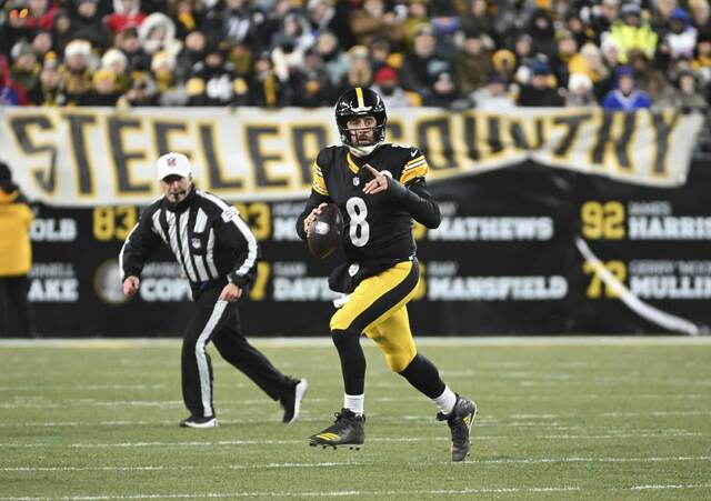 Steelers quarterback Aaron Rodgers rolls out against the Bills in the second round quarter Sunday at Acrisure Stadium.