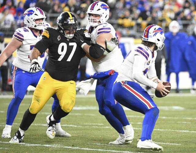 Buffalo Bills quarterback Josh Allen gets away from Pittsburgh Steelers defensive tackle Cam Heyward during Sunday’s game at Acrisure Stadium. Heyward accused Allen of kneeing him after an Allen touchdown pass during the third quarter.