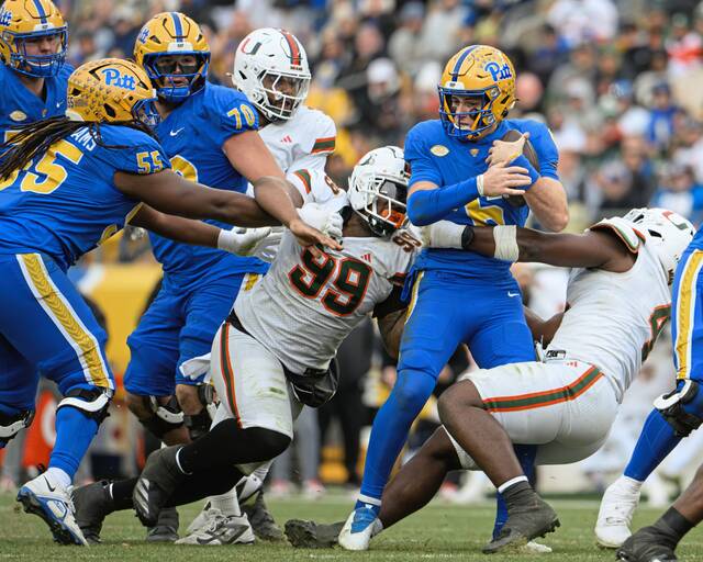 Pitt quarterback Mason Heintschel (6) is sacked by Miami's Ahmad Moten Sr. (99) and Rueben Bain Jr. (4) on Saturday, Nov. 29, 2025, at Acrisure Stadium.