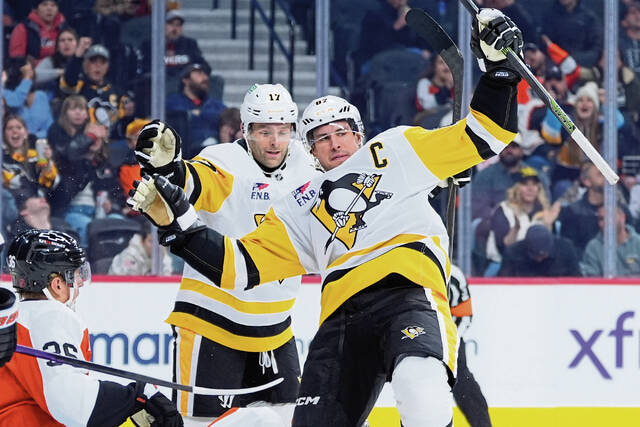 The Penguins’ Sidney Crosby (right) and Bryan Rust celebrate after a goal by Crosby during the first period against the Flyers on Monday in Philadelphia.
