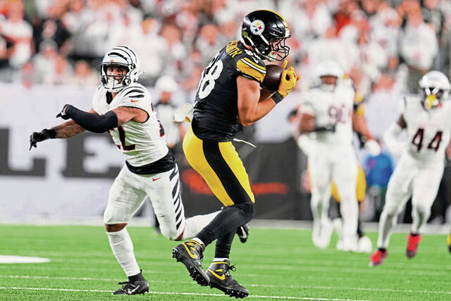 Pittsburgh Steelers tight end Pat Freiermuth (right) catches a pass from quarterback Aaron Rodgers and runs for a touchdown with Cincinnati Bengals safety Geno Stone defending during the second half of a game in Cincinnati (AP)