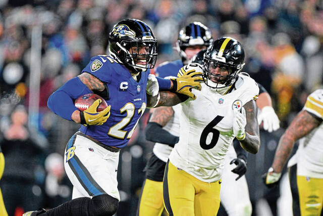 Ravens running back Derrick Henry stiff-arms Steelers linebacker Patrick Queen (6) as he runs for a touchdown during the second half of a wild-card game last season.