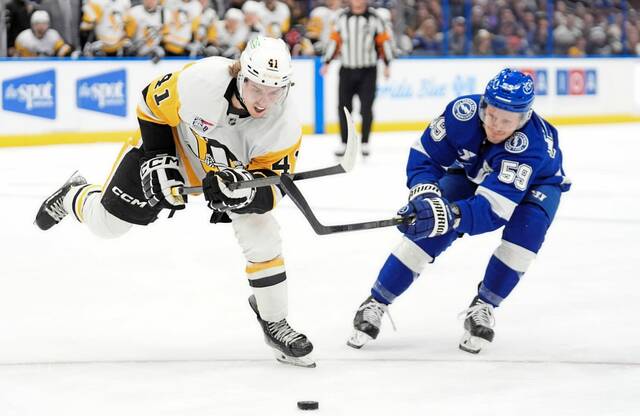 Pittsburgh Penguins right wing Ville Koivunen (41) beats Tampa Bay Lightning center Jake Guentzel (59) to the puck during the first period of an NHL hockey game Thursday, Dec. 4, 2025, in Tampa, Fla. (AP)