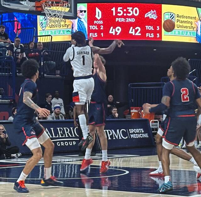 Duquesne’s Tarence Guinyard dishes off in the lane against Stony Brook on Saturday at UPMC Cooper Fieldhouse. (Dave Mackall | For TribLive)