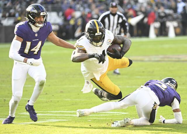 Pittsburgh Steelers receiver DK Metcalf dives over Baltimore Ravens defensive back Nate Wiggins during the second quarter of Sunday’s game at M&T Bank Stadium. Metcalf stayed the night in Baltimore because of a stomach ailment but was expected to return to Pittsburgh on Monday. (Chaz Palla | TribLive)