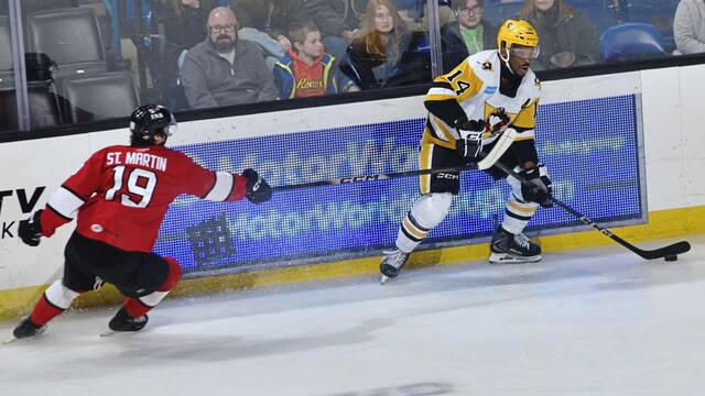 Wilkes-Barre/Scranton Penguins forward Boko Imama protects a puck from Charlotte Checkers forward Hunter St. Martin during a game at Mohegan Arena in Wilkes-Barre on Sunday. The Checkers won, 6-2. (KDP Studio)