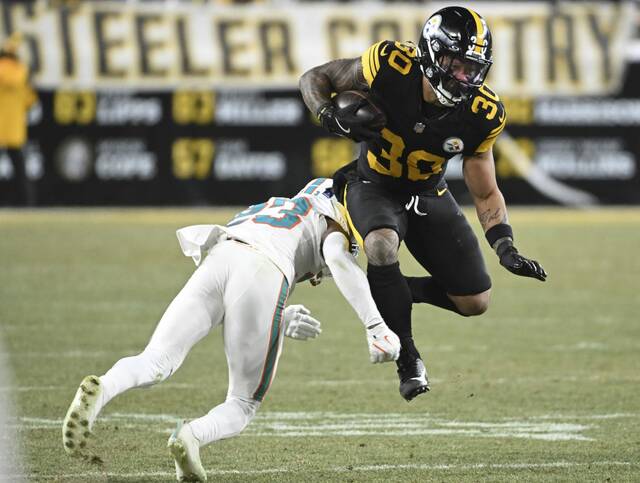 Steelers running back Jaylen Warren avoids the Dolphins’ Jack Jones in the first quarter Monday at Acrisure Stadium. (Chaz Palla | TribLive)