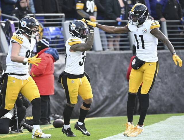 Pittsburgh Steelers wide receiver Marquez Valdes-Scantling (right, No. 11) celebrates with Jaylen Warren (middle) after Warren’s touchdown against the Baltimore Ravens during the Dec. 7 game at M&T Bank Stadium. A practice-squad call-up for that game, Valdes-Scantling was signed to the active roster Monday. (Chaz Palla | TribLive)