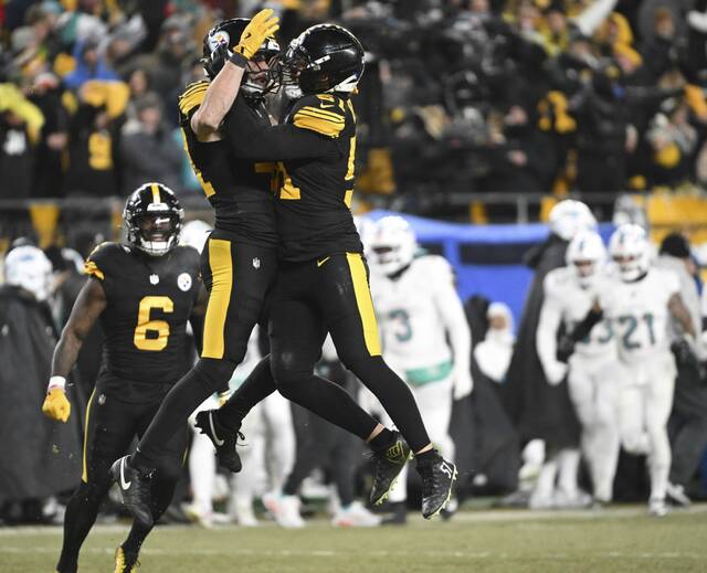 Pittsburgh Steelers linebackers Nick Herbig and Payton Wilson celebrate after Wilson’s sack of Miami Dolphins quarterback Tua Tagovailoa during the third quarter of Monday’s game at Acrisure Stadium. The victory assures the Steelers will at worst be playing for the AFC North title when they host the Baltimore Ravens in Week 18. (Chaz Palla | TribLive)
