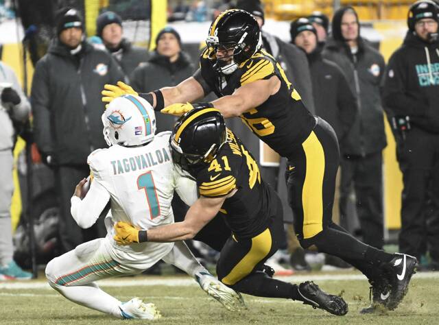The Steelers’ Nick Herbig helps Payton Wilson with the sack of Dolphins quarterback Tua Tagovailoa in the third quarter Monday at Acrisure Stadium. (Chaz Palla | TribLive)