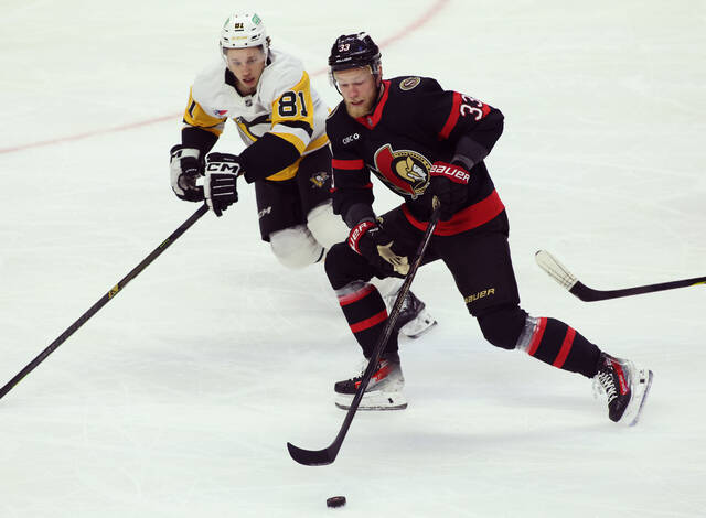 Ottawa’s Nikolas Matinpalo carries the puck while being chased by the Penguins’ Ben Kindel during the first period Thursday. (The Canadian Press via AP)